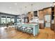 Open-concept kitchen with island seating, hardwood floors, custom cabinets, and dining area at 5120 Melbourne Pl, Zionsville, IN 46077