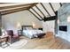 Spacious main bedroom with vaulted ceilings, wood floors, and comfortable sitting area by decorative fireplace at 5120 Melbourne Pl, Zionsville, IN 46077