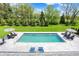 Aerial view of a private backyard with a sparkling pool, lounge chairs and lush greenery at 5120 Melbourne Pl, Zionsville, IN 46077