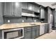 Modern wet bar with stainless steel appliances, dark cabinetry and granite countertops for entertaining at 5120 Melbourne Pl, Zionsville, IN 46077