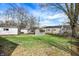 Large grassy backyard featuring an outbuilding and a mix of bare and leafy trees at 5350 E 20Th Pl, Indianapolis, IN 46218
