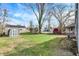 Large grassy backyard featuring several outbuildings and a mix of bare and leafy trees at 5350 E 20Th Pl, Indianapolis, IN 46218