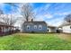 Well maintained backyard with a blue house, green grass and open carport at 5350 E 20Th Pl, Indianapolis, IN 46218