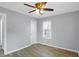 A simple bedroom featuring a ceiling fan, window, and wood-look flooring at 5350 E 20Th Pl, Indianapolis, IN 46218