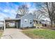 Charming blue home featuring a covered carport, a shed, and a cozy front porch at 5350 E 20Th Pl, Indianapolis, IN 46218