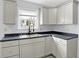 A kitchen features gray cabinets, stainless sink, dark countertops, and a window view at 5350 E 20Th Pl, Indianapolis, IN 46218