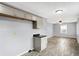 A bright kitchen features gray cabinets, dark countertops, wood floors and a view of the living area at 5350 E 20Th Pl, Indianapolis, IN 46218
