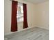 This bedroom has a neutral color, light colored flooring, and red curtains at 553 N Traub Ave, Indianapolis, IN 46222