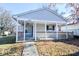 Inviting single story home showing the covered front porch and walkway on a sunny day at 553 N Traub Ave, Indianapolis, IN 46222