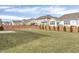 Large, open backyard with a healthy lawn, framed by a wooden fence and featuring a cozy patio area at 5540 Arrowgrass Ct, Noblesville, IN 46062