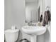 Neat half-bath with white pedestal sink and toilet with simple decor at 5540 Arrowgrass Ct, Noblesville, IN 46062
