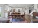Open-concept dining area adjacent to a kitchen, featuring dark wood furniture and a staircase at 5540 Arrowgrass Ct, Noblesville, IN 46062