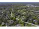 An aerial view shows the house nestled within a lush, green neighborhood of similar homes and tree-lined streets at 5836 Andover Rd, Indianapolis, IN 46220