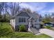 Beautifully landscaped front yard leads to an updated home with a white garage door and mature shade trees at 5836 Andover Rd, Indianapolis, IN 46220