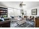 Bright living room with large windows, ceiling fan, and a cozy seating arrangement over a decorative rug at 5836 Andover Rd, Indianapolis, IN 46220