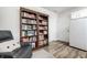Living room featuring large bookshelf, a comfy armchair, and hardwood floors at 5836 Andover Rd, Indianapolis, IN 46220