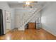 Inviting living room with hardwood floors, white staircase, and convenient mini fridge at 602 Prospect St, Indianapolis, IN 46203