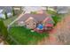 Aerial view of home with a large deck, mature trees, and well-manicured lawn at 6043 Acorn Dr, Columbus, IN 47201
