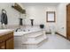 Bathroom featuring a tub with tile surround, decorative shelves, and a matching toilet at 6043 Acorn Dr, Columbus, IN 47201