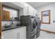 Convenient laundry room featuring a sink with stylish faucet, gray appliances and a view from the window at 6043 Acorn Dr, Columbus, IN 47201