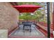 Outdoor seating on wooden deck with colorful red umbrella for shade at 6043 Acorn Dr, Columbus, IN 47201