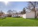 Wide backyard with grass, white house, and detached garage at 6721 Evanston Ave, Indianapolis, IN 46220