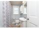Clean bathroom with a shower, toilet, sink, cabinet and a patterned shower curtain at 6721 Evanston Ave, Indianapolis, IN 46220