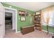 Spacious bedroom with green walls, posters, and a cozy reading nook at 6721 Evanston Ave, Indianapolis, IN 46220
