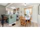 Cozy dining area adjacent to kitchen, featuring wood table set, bright lighting, and functional breakfast bar at 6721 Evanston Ave, Indianapolis, IN 46220