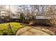 Large backyard with mature trees, circular paver area, and wood fence at 7021 Warwick Rd, Indianapolis, IN 46220