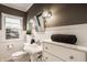 Elegant bathroom featuring a pedestal sink, wainscoting, and a marble countertop at 7021 Warwick Rd, Indianapolis, IN 46220
