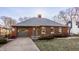 Charming red brick home with gray shutters, attached garage and well maintained lawn at 7021 Warwick Rd, Indianapolis, IN 46220