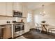 Bright kitchen boasts stainless steel appliances, sleek cabinetry, and an adjacent breakfast nook with a decorative chandelier at 7021 Warwick Rd, Indianapolis, IN 46220