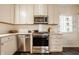 Stylish kitchen featuring stainless steel appliances, white cabinets and tile backsplash at 7021 Warwick Rd, Indianapolis, IN 46220