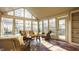 Inviting sunroom filled with natural light, wicker furniture, and beautiful brick flooring at 7021 Warwick Rd, Indianapolis, IN 46220