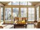 Bright sunroom featuring wicker furniture, brick floors, and a wall of windows at 7021 Warwick Rd, Indianapolis, IN 46220