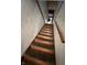 View of a carpeted stairway leading to a basement with a wooden handrail and white walls at 805 W 3Rd St, Alexandria, IN 46001