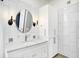 Bright bathroom features a round mirror, white vanity, and sleek, modern fixtures at 932 Broadway St # 15, Indianapolis, IN 46202
