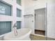 Modern bathroom featuring a sleek freestanding tub and a luxurious glass enclosed shower at 932 Broadway St # 15, Indianapolis, IN 46202