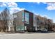 Modern townhome complex featuring a blend of dark brick and white siding, highlighted by expansive windows and professional landscaping at 932 Broadway St # 15, Indianapolis, IN 46202