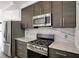 Kitchen featuring stainless steel appliances, dark wood cabinets, and marble countertops at 932 Broadway St # 15, Indianapolis, IN 46202