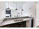 Kitchen with stainless steel sink and appliances, marble counters and modern pendant lighting at 932 Broadway St # 15, Indianapolis, IN 46202