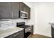 Modern kitchen with stainless steel appliances, marble countertops, and dark wood cabinetry at 932 Broadway St # 15, Indianapolis, IN 46202