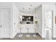 Bright kitchen features a breakfast bar with pendant lighting, white cabinetry, and modern stainless steel appliances at 932 Broadway St # 15, Indianapolis, IN 46202