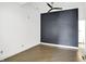 A view of the main bedroom with hardwood floors and accent wall at 932 Broadway St # 15, Indianapolis, IN 46202