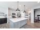 Well-lit kitchen with large island, stainless appliances, gray cabinets and modern pendant lights at 981 Mound St, Bargersville, IN 46106