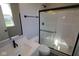 Modern bathroom features sleek vanity with solid surface countertop and walk-in shower with sliding glass door at 10609 Banyan Wood Ct, Indianapolis, IN 46239