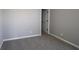 A well-lit bedroom featuring neutral walls, plush gray carpeting, and easy access to a hallway at 10609 Banyan Wood Ct, Indianapolis, IN 46239