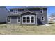 Rear view of a two-story home featuring a patio, large windows, and dark siding at 10609 Banyan Wood Ct, Indianapolis, IN 46239