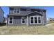 Rear view of a two-story home featuring a patio, large windows, and dark siding at 10609 Banyan Wood Ct, Indianapolis, IN 46239